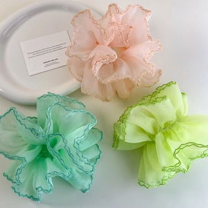 Détail de chouchous géants en organza avec volants plissés en rose pastel et vert menthe