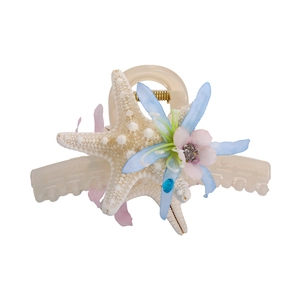 Close-up detail of ocean starfish and flower hair clip with a blue crystal and resin finish