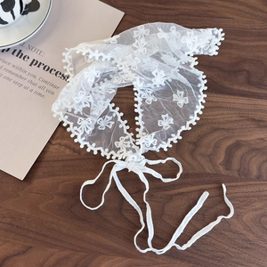 Detail of white lace waist ribbon with floral embroidery and delicate scallop edges
