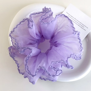 Vue détaillée d'un chouchou en organza violet à bords plissés et multicouches