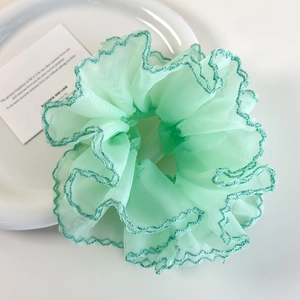 Vue détaillée du chouchou en organza vert menthe avec broderie festonnée vert foncé