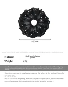 Détail montrant le grand chouchou en dentelle noire de 22 cm avec des perles fantaisie