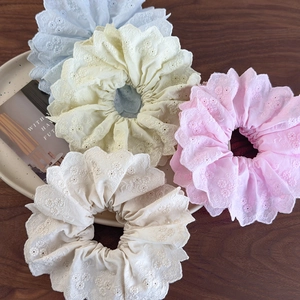 Detailed close-up of eyelet embroidery lace scrunchies in four pastel floral colors