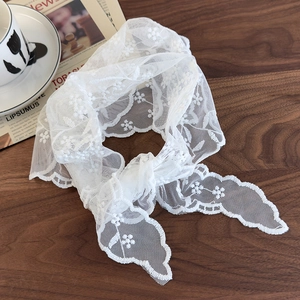 Close-up of white French vintage lace scarf with floral embroidery on dark wood