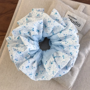 Détail macro d'un chouchou à fleurs bleu clair avec une texture de tissu doux