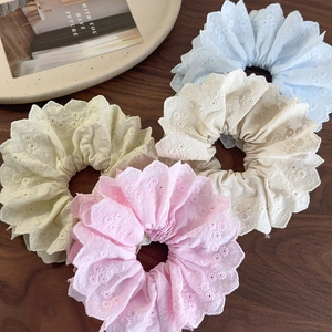 Floral embroidered lace scrunchies set in pastel colors on a wooden background