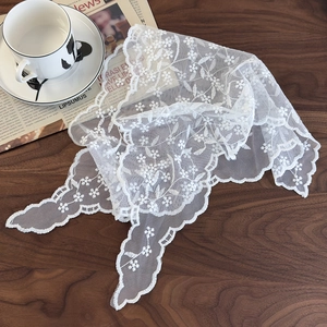 Detail view of white lace scarf with floral embroidery on dark walnut table