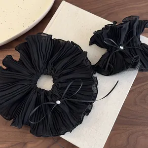 Detail view of large black mesh hair scrunchies with rhinestones on a vintage background