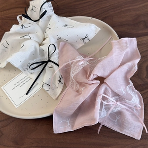 Detail of ballet style lace ribbon scrunchies with bow prints in a ceramic dish