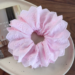 Detailed view of pink floral embroidery lace scrunchie on a ceramic display tray
