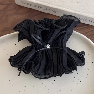 Close-up of a French vintage black mesh scrunchie with a rhinestone bow on a tray