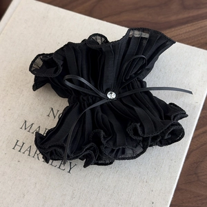Detailed close-up of large black mesh hair scrunchie with rhinestones and ribbon bow
