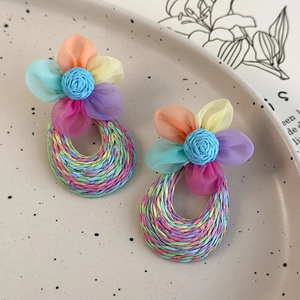 Detailed macro view of colorful mesh flower earrings with handwoven teardrop hoops