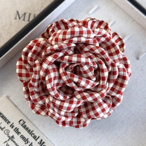 Macro shot of red and white gingham fabric flower hair claw with intricate petal textures
