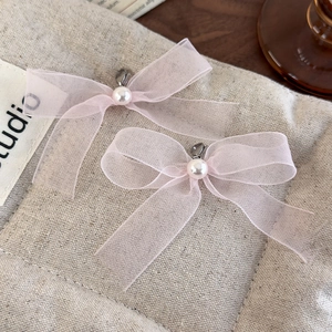 Detail of light pink organza ribbon bow with pearl accent for ballet style sneaker decor