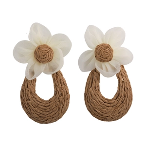 Handmade woven flower earrings with white petals and brown straw teardrop pendants