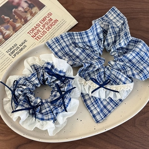 Detail of blue plaid hair scrunchie set with white lace trim and satin bow accents