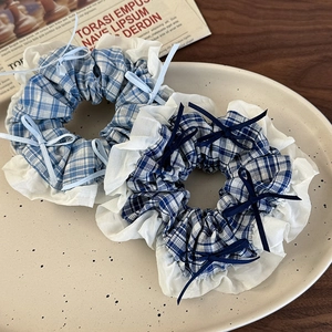 Detail showing blue plaid scrunchies with white lace edges and dainty ribbon bows
