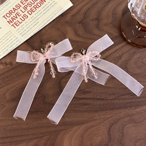 Detail of pink organza ribbon bow and crystal beaded charms with lobster clasp