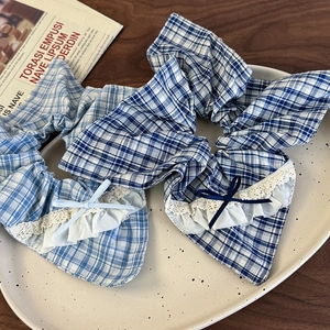 Close-up of blue plaid scrunchie with white lace edges and a delicate bow detail