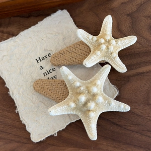 Close-up of set of two starfish hair clips with natural resin texture and woven base