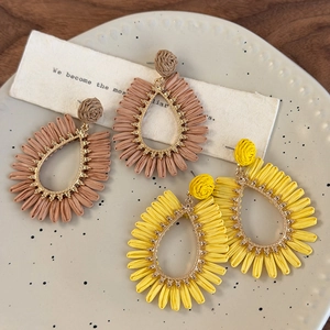 Bohemian teardrop straw woven earrings in yellow and tan colors for beach vacations