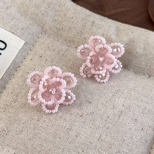 Macro detail of handmade pink beaded flower charms with transparent crystal accents
