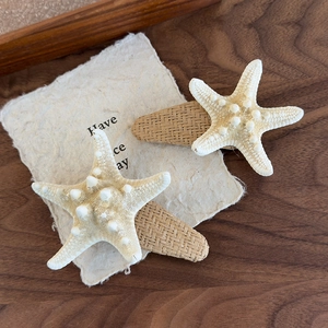 Detailed close-up of woven star-shaped hair clips with realistic starfish texture and design