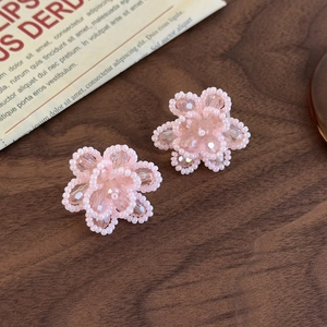 Close-up of pink crystal beaded flower shoe charms on a vintage wooden background
