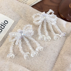 Close-up of beaded crystal bow with elegant tassels and transparent flower pendants