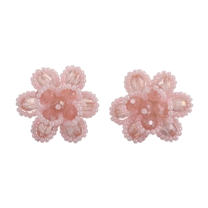 Handmade light pink beaded flower earrings with a faceted center on a white background
