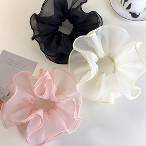 Detailed close-up of three layered mesh hair scrunchies in black, white, and pink colors