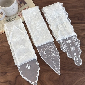 Lot de rubans en dentelle blanche avec broderie florale sur table en bois rustique