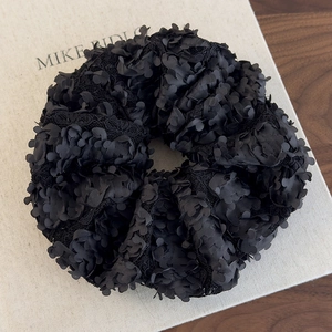 Détail de chouchou noir à pétales 3D multicouches avec dentelle et maille brillante