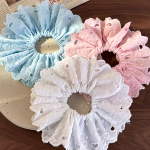Detailed close-up of eyelet lace embroidery hair scrunchies in blue, pink and white