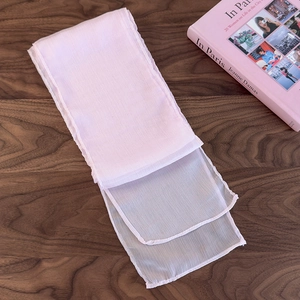 Detail view of lightweight light pink silk scarf folded on a rustic wooden table background