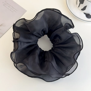 Close-up of black oversized mesh scrunchie with pleated layers and fine stitching detail