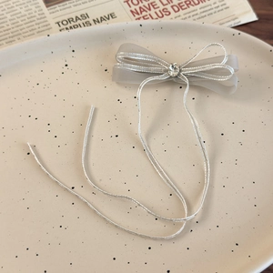 Detail of grey mesh bow hair clip with sparkling rhinestone and long silver streamers
