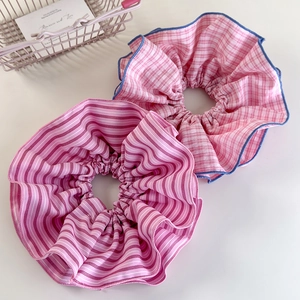 Detailed view of pink striped and checkered scrunchie set with blue contrast stitching