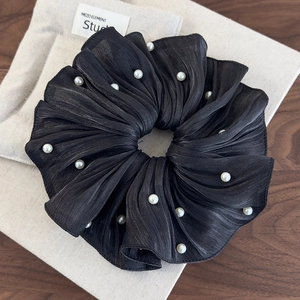 Détail du chouchou en satin noir plissé haut de gamme avec accents de perles blanches