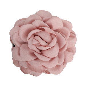 Détail d'une pince à cheveux rose en forme de rose avec des pétales en mousseline