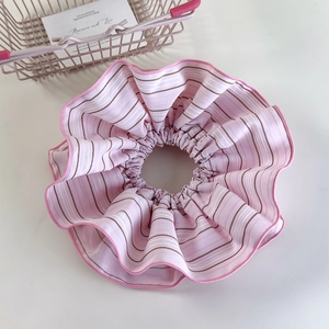 Detail view of pink striped oversized scrunchie hair tie with delicate chiffon fabric texture