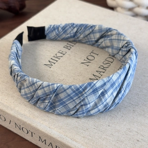 Detail of blue and white plaid fabric headband with pleated texture and ribbon ends