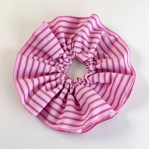Detailed view of pink and white striped scrunchie fabric texture with soft ruffles