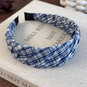 Detail of blue and white plaid pleated headband on a book showing fabric texture