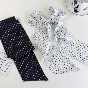 Close-up of elegant black and white polka dot silk scarves with a French cafe aesthetic