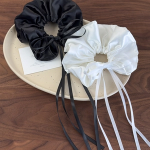 Elegant set of black and white satin scrunchies with long ribbon bows for hair styling