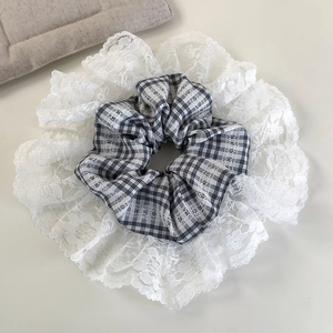 Close-up of black and white plaid hair scrunchie with wide white floral lace edges