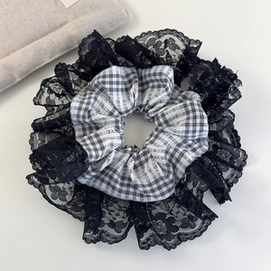 Close-up of black and white plaid hair scrunchie with delicate floral lace edging