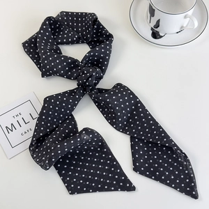 Detail of a black polka dot neck scarf in soft chiffon fabric tied in a classic knot